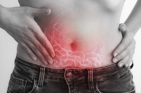Frau tastet ihren Bauch auf Höhe des Darms ab